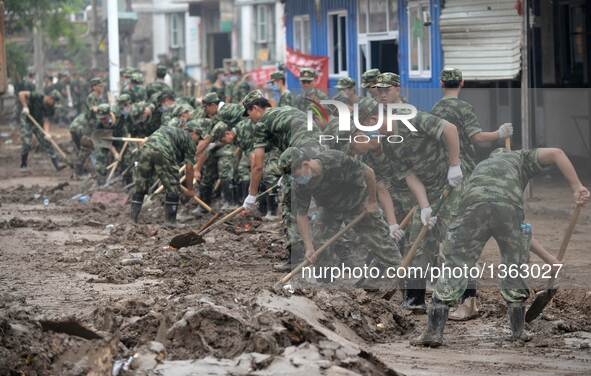 Soldiers clean up streets in Jingxing County, north China's Hebei Province, July 29, 2016. A total of 2,400 soldiers have been dispatched to...