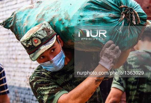 A soldier works in a residential area in Jingxing County, north China's Hebei Province, July 29, 2016. A total of 2,400 soldiers have been d...