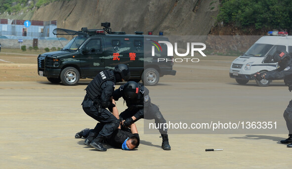 Police officers bring a man who violently attacked a public security checkpoint under control during an anti-terrorism drill in Fusui County...