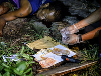 (EDITORS NOTE: Image depicts graphic content.) A police investigator shows recovered sachets of crystal meth known locally as "shabu" and ca...