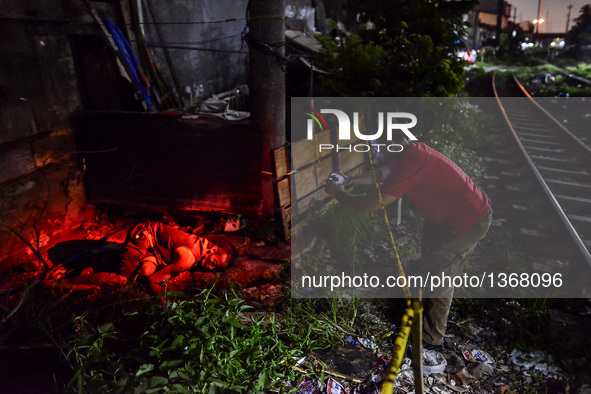 (EDITORS NOTE: Image depicts graphic content.) A member of the police's homicide division takes pictures of the corpse of a suspected drug p...