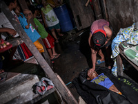 (EDITORS NOTE: Image depicts graphic content.) A resident covers the face of a suspected drug pusher who was shot dead following a police op...