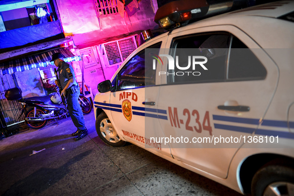 A police officer stands guard outside a house where three suspected drug pushers were shot dead following a police operation in Manila, Phil...