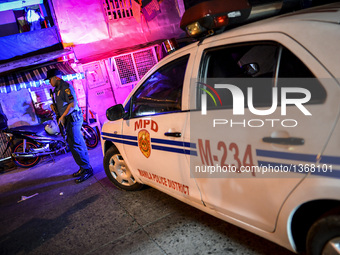 A police officer stands guard outside a house where three suspected drug pushers were shot dead following a police operation in Manila, Phil...