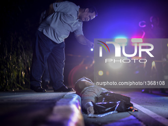 (EDITORS NOTE: Image depicts graphic content.) A member of the police's homicide division inspects the corpse of a suspected drug addict and...