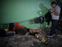 (EDITORS NOTE: Image depicts graphic content.) A member of the police's homicide division takes pictures of the corpse of a suspected house...