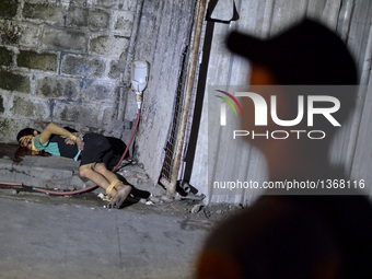 (EDITORS NOTE: Image depicts graphic content.) A police officer stands next to the corpse of a suspected drug pusher and victim of a vigilan...