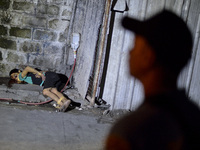 (EDITORS NOTE: Image depicts graphic content.) A police officer stands next to the corpse of a suspected drug pusher and victim of a vigilan...