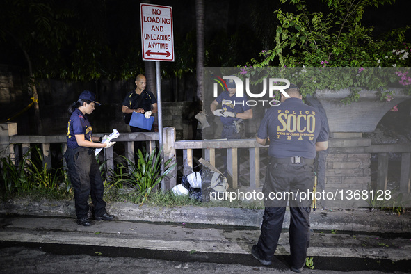 (EDITORS NOTE: Image depicts graphic content.) Police investigators inspect the corpse of a suspected drug pusher and victim of a vigilante-...