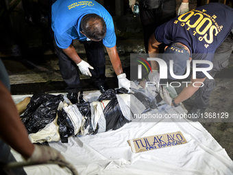 (EDITORS NOTE: Image depicts graphic content.) Police investigators inspect the corpse of a suspected drug pusher and victim of a vigilante-...