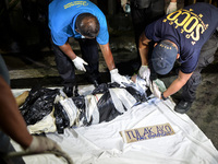 (EDITORS NOTE: Image depicts graphic content.) Police investigators inspect the corpse of a suspected drug pusher and victim of a vigilante-...