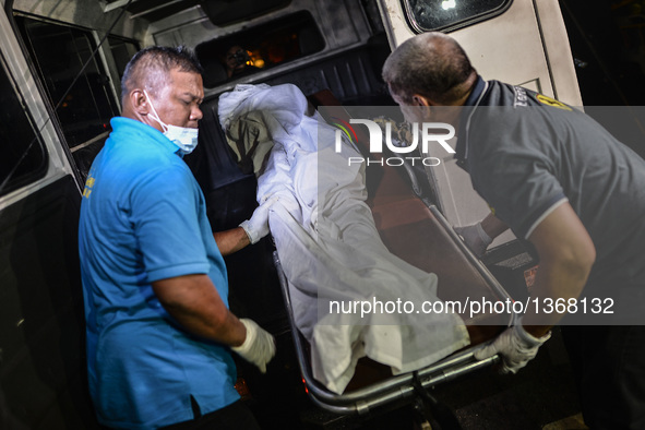 (EDITORS NOTE: Image depicts graphic content.) Morgue personnel load the the corpse of a suspected drug pusher and victim of a vigilante-sty...