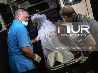 (EDITORS NOTE: Image depicts graphic content.) Morgue personnel load the the corpse of a suspected drug pusher and victim of a vigilante-sty...