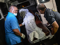 (EDITORS NOTE: Image depicts graphic content.) Morgue personnel load the the corpse of a suspected drug pusher and victim of a vigilante-sty...