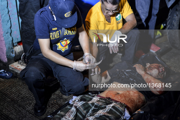 (EDITORS NOTE: Image depicts graphic content.) A police investigator collects fingerprints from a corpse of a suspected drug pusher after he...