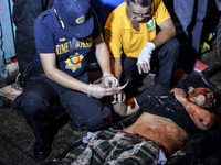 (EDITORS NOTE: Image depicts graphic content.) A police investigator collects fingerprints from a corpse of a suspected drug pusher after he...