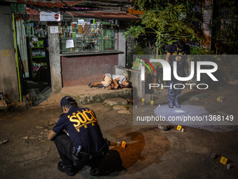 (EDITORS NOTE: Image depicts graphic content.) Police investigators inspect empty bullet shells scattered on the ground as the corpse of a s...