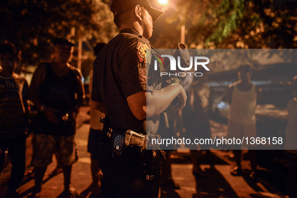 (EDITORS NOTE: Image depicts graphic content.) A police officer stands guard near a crime scene where a suspected drug runner was shot dead...