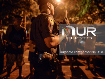 (EDITORS NOTE: Image depicts graphic content.) A police officer stands guard near a crime scene where a suspected drug runner was shot dead...