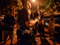 (EDITORS NOTE: Image depicts graphic content.) A police officer stands guard near a crime scene where a suspected drug runner was shot dead...