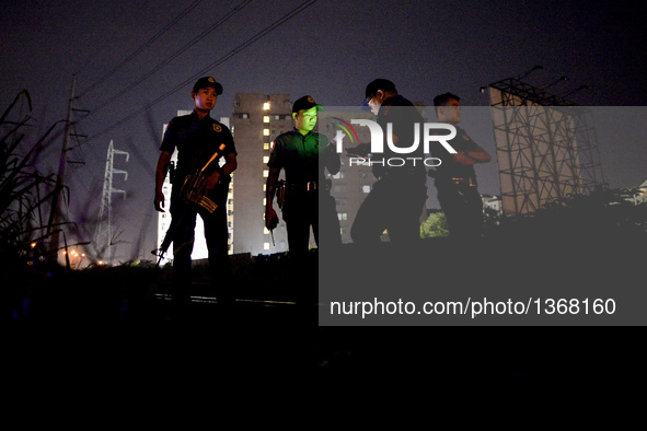 (EDITORS NOTE: Image depicts graphic content.) Police officers stand guard near a crime scene where a suspected drug pusher was shot dead fo...