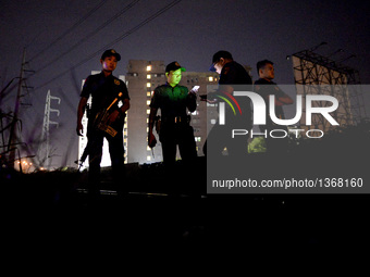 (EDITORS NOTE: Image depicts graphic content.) Police officers stand guard near a crime scene where a suspected drug pusher was shot dead fo...