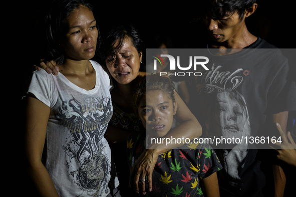 (EDITORS NOTE: Image depicts graphic content.) Relatives of a suspected drug pusher weep after he was shot dead following a police operation...