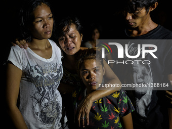 (EDITORS NOTE: Image depicts graphic content.) Relatives of a suspected drug pusher weep after he was shot dead following a police operation...