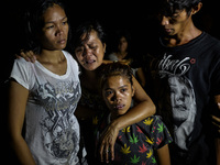 (EDITORS NOTE: Image depicts graphic content.) Relatives of a suspected drug pusher weep after he was shot dead following a police operation...