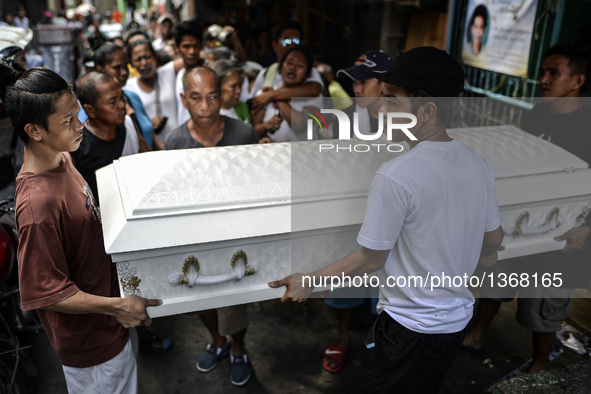 Relatives carry the coffin of a suspected drug pusher and victim of a vigilante-style execution during a burial ceremony in Pasay, south of...