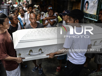 Relatives carry the coffin of a suspected drug pusher and victim of a vigilante-style execution during a burial ceremony in Pasay, south of...