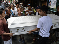 Relatives carry the coffin of a suspected drug pusher and victim of a vigilante-style execution during a burial ceremony in Pasay, south of...