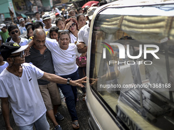 Relatives of a suspected drug pusher and victim of a vigilante-style execution grieve during a burial ceremony in Pasay, south of Manila, Ph...