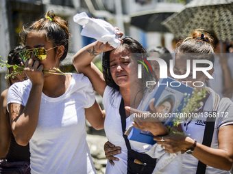 (EDITORS NOTE: Image depicts graphic content.) Relatives of a suspected drug pusher and victim of a vigilante-style execution grieve during...