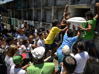 The coffin of a suspected drug pusher and victim of a vigilante-style execution is placed on a tomb as relatives grieve during a burial cere...