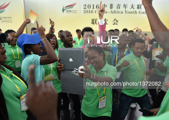 An African girl takes a picture at the 2016 China-Africa Youth Gala in Guangzhou, capital of south China's Guangdong Province, Aug. 4, 2016....