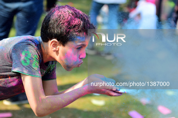 A boy plays with colored powder at the India Color Festival during a high temperature summer day in Cairo, Egypt, on August 12, 2016.