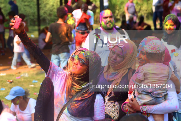 People take selfies at the India Color Festival during a high temperature summer day in Cairo, Egypt, on August 12, 2016.