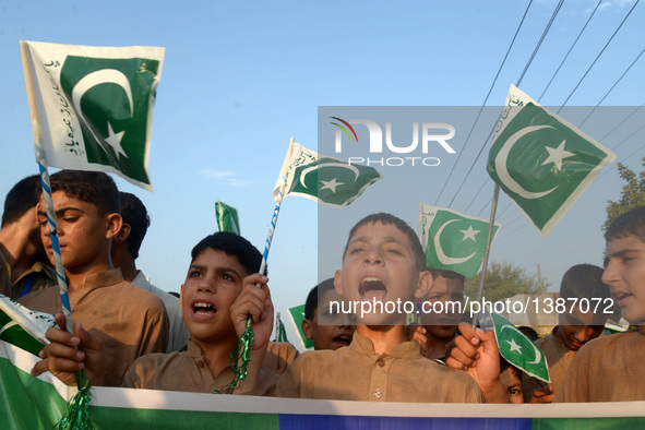 Pakistani children wave national flags during a ceremony to mark Pakistan's Independence Day in northwest Pakistan's Peshawar on Aug. 14, 20...