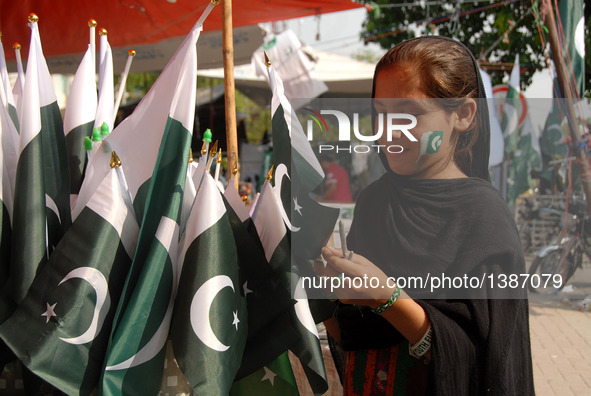 A girl buys national flags from a stall on Pakistan's Independence Day in Islamabad, capital of Pakistan on Aug. 14, 2016.