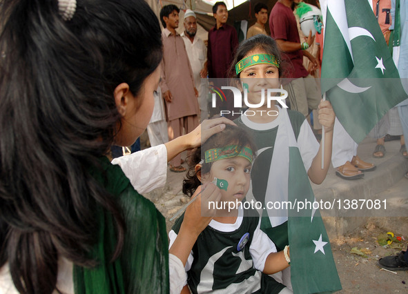 A woman paints a flag on the face of a child on Pakistan's Independence Day in Islamabad, capital of Pakistan on Aug. 14, 2016.