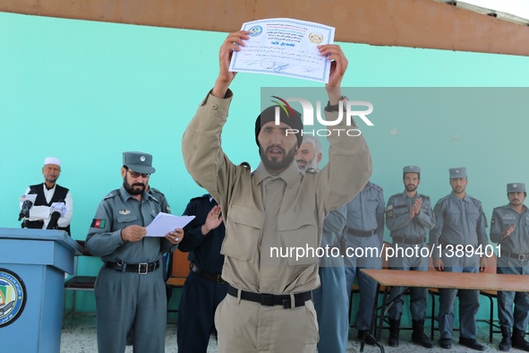 An Afghan policeman shows his certificate during his graduation ceremony in Ghazni province, Afghanistan, Aug. 16, 2016. A total of 130 loca...