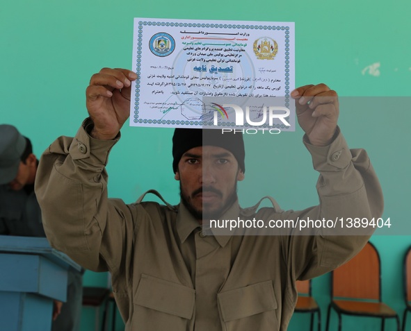 An Afghan policeman shows his certificate during his graduation ceremony in Ghazni province, Afghanistan, Aug. 16, 2016. A total of 130 loca...