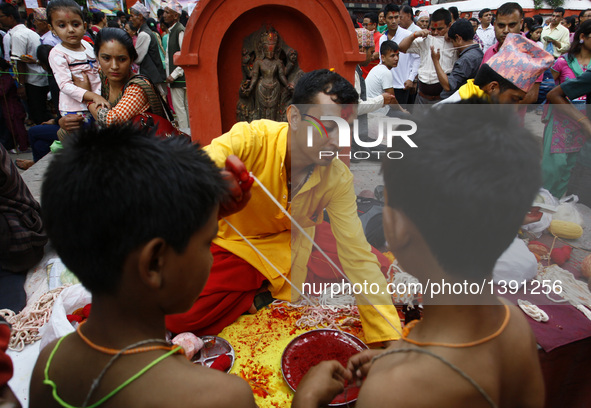 A Nepalese priest prepares holy thread during Janai Purnima Festival at Lalitpur, Nepal, Aug. 18, 2016. Janai Purnima, also known as the fes...