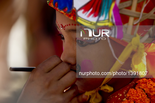 A boy with makeup on his face participates in a parade during the Gaijatra festival, or the festival of cows, in Kathmandu, capital of Nepal...