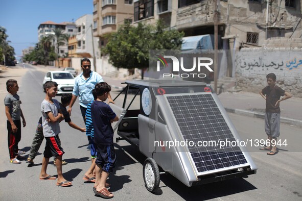 Palestinian children watch the solar car made by Palestinian students Jamal Mikaty and Khaled Bardawil in Gaza City, on Aug. 16, 2016. Two P...