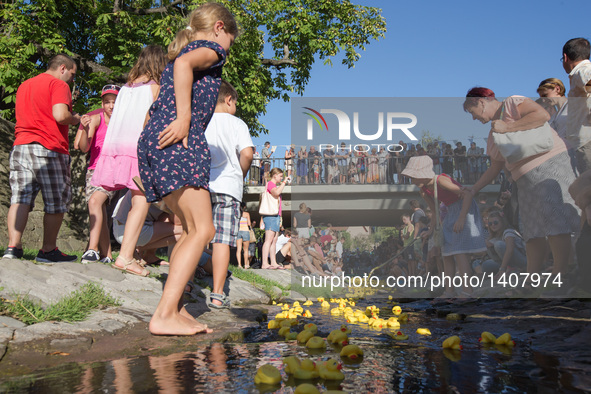 People watch a thousand rubber ducks race on Bukkos creek during a charity event in Szentendre, Hungary, on Aug. 27, 2016.