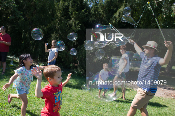 Children run after soap bubbles on the soap bubble day at a park in Budapest, Hungary, Aug. 28. 2016.