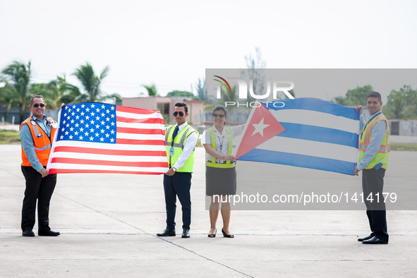 Personnel of the ground service pose for pictures with national flags of Cuba and the U.S., welcoming the first commercial flight from U.S.,...