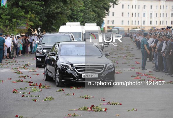 People gather along the road to watch the vehicle carrying the coffin of the late president of Uzbekistan Islam Karimov in Samarkand, Uzbeki...